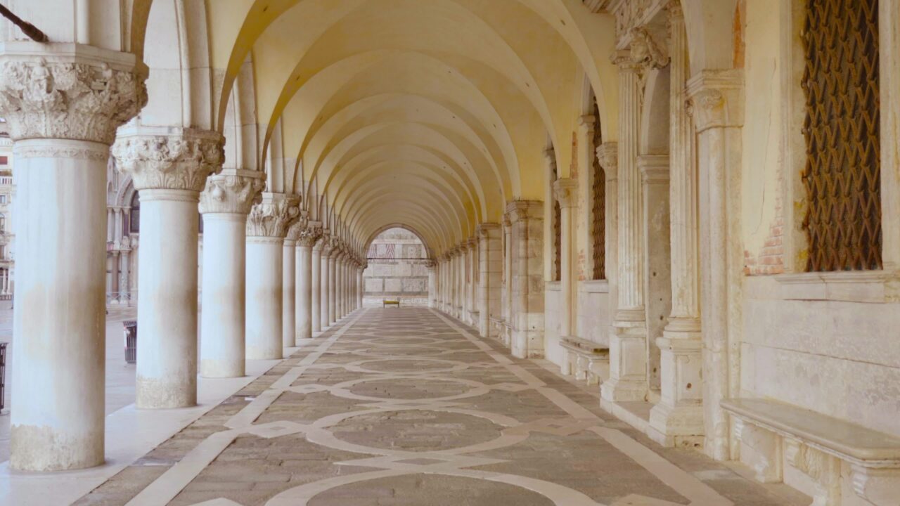 Under Venetian arcades with white columns