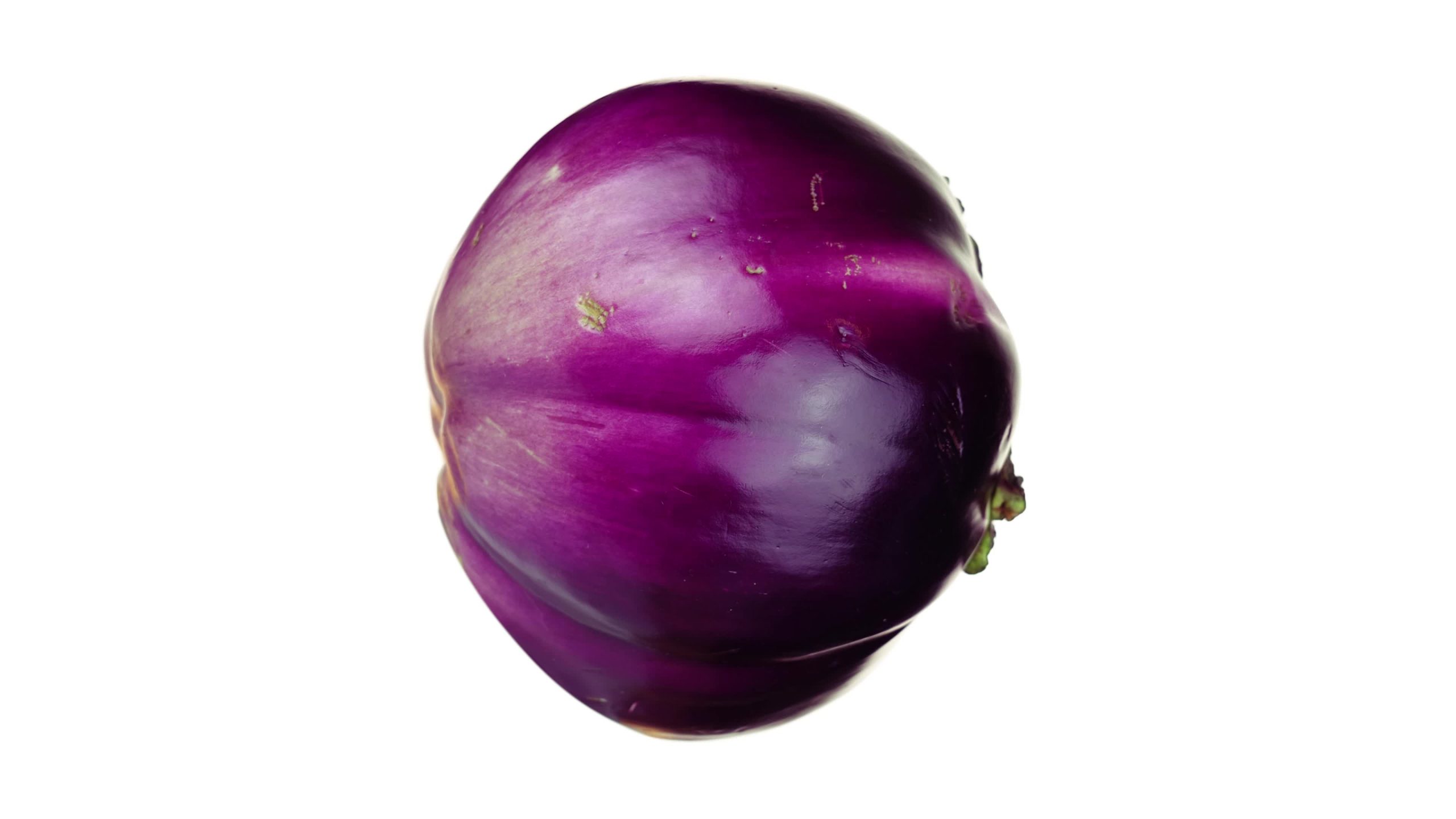 Ripe round eggplant slowly rotates on a white background