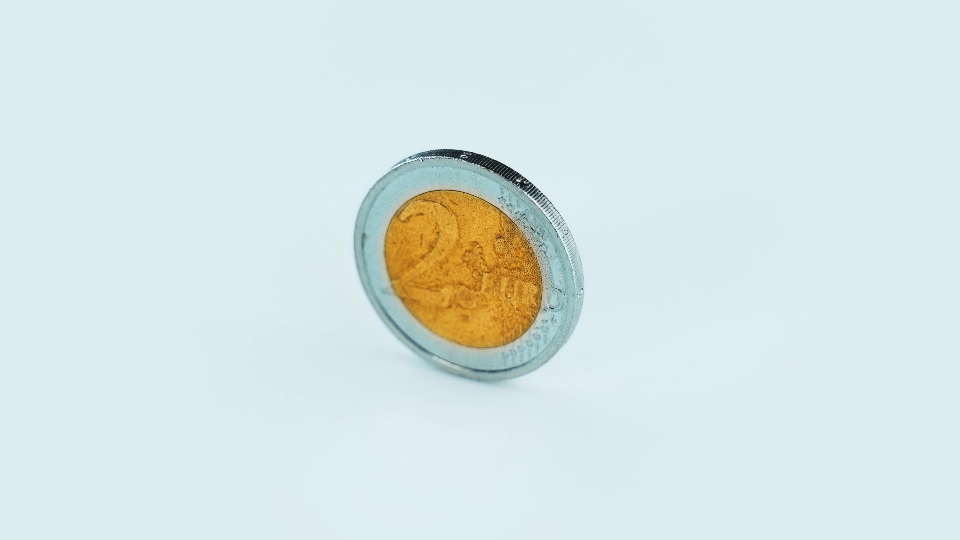 Two euro coin rotates on white background