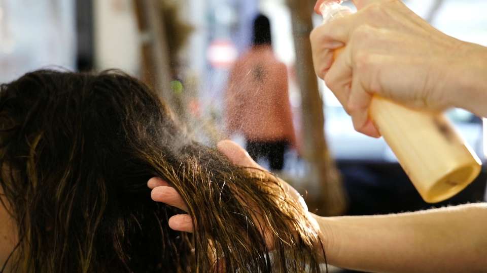 Spray viene applicato sui capelli bagnati della signora dal parrucchiere