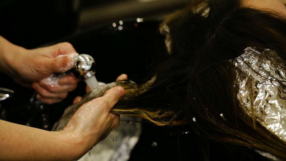 Woman’s hair is washed in slow motion in the beauty salon