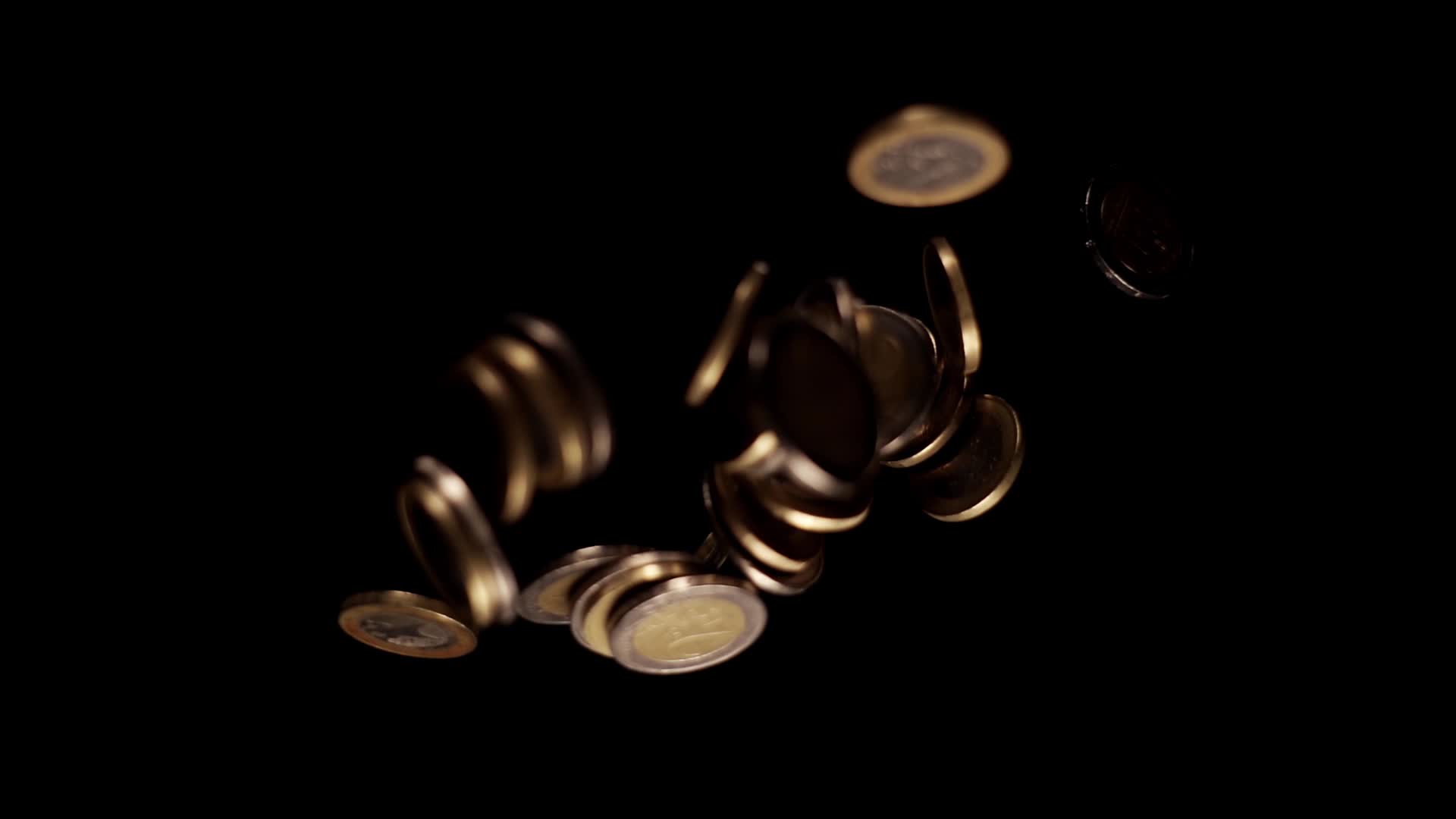 Small golden and silver coins fall down reflecting light
