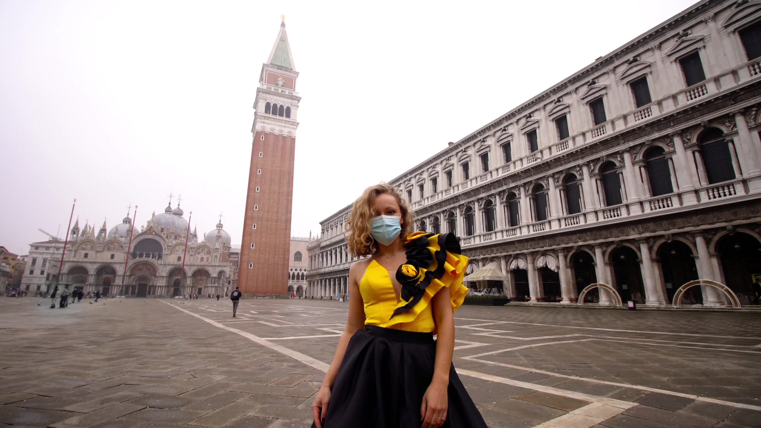 Donna in abito e maschera medica posa su piazza venezia vuota