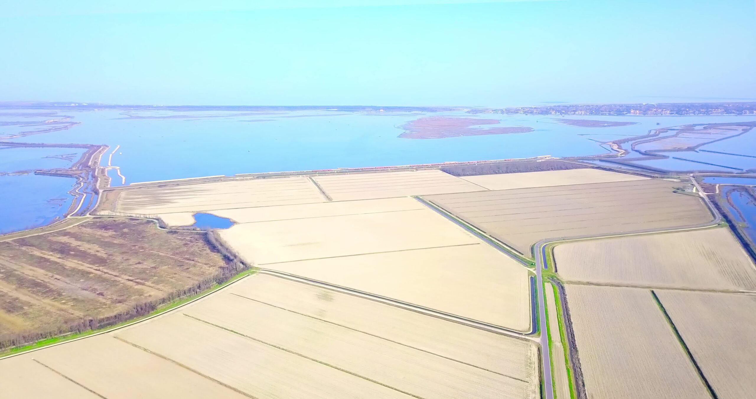 Natura lagunare blu vicino a polder nobilitati e campi senza semi