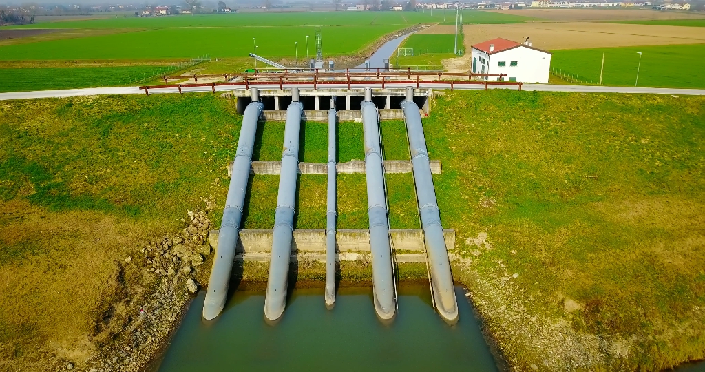 Sistema di irrigazione sul fiume sotto il ponte in zona di campagna