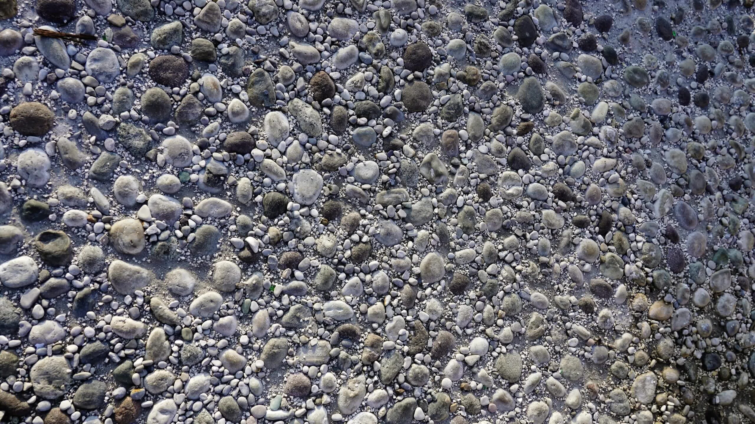 Marciapiede grigio vintage di piccoli ciottoli sotto la luce del sole