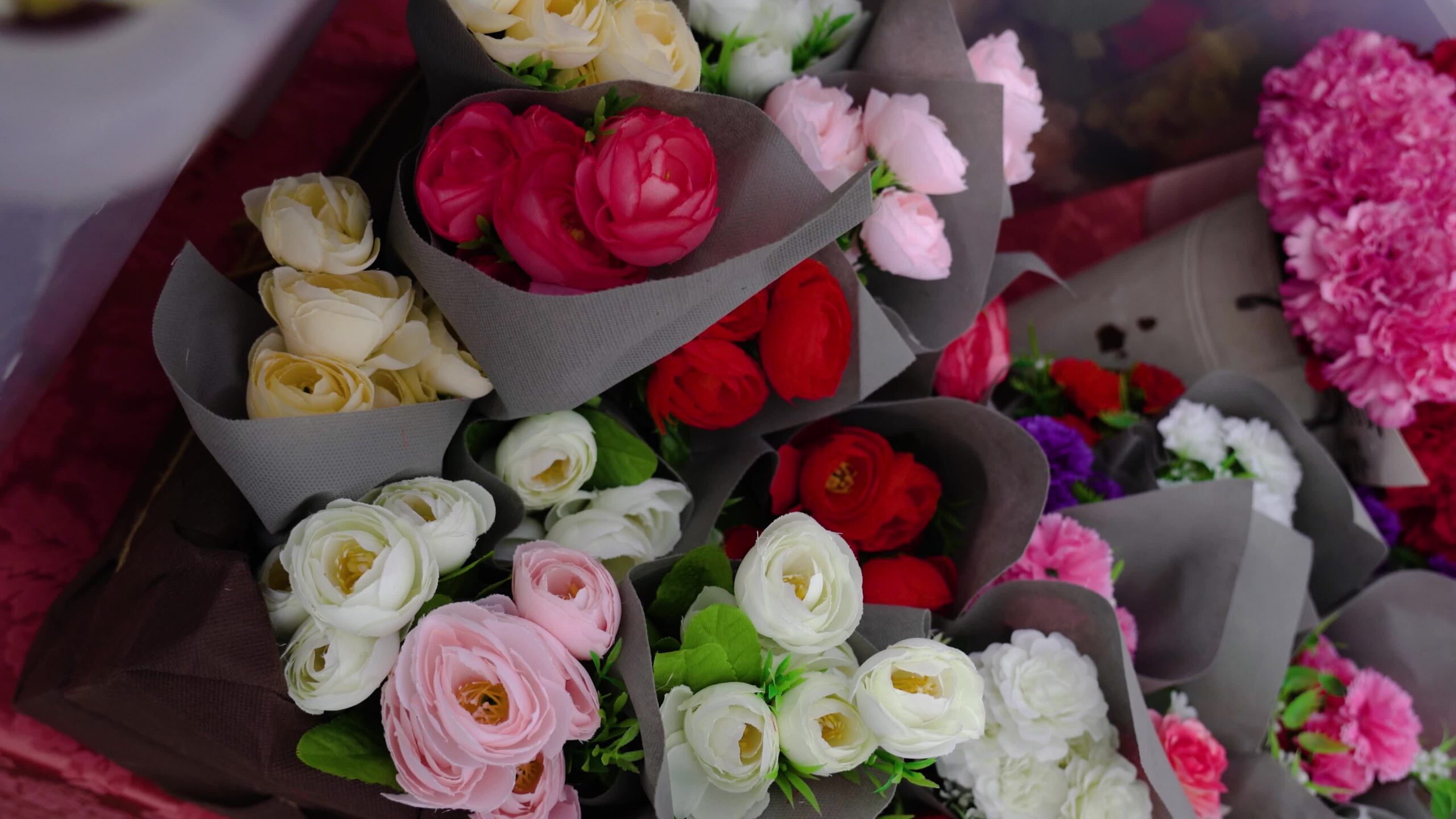 Movimento su composizioni di rose colorate avvolte in carta