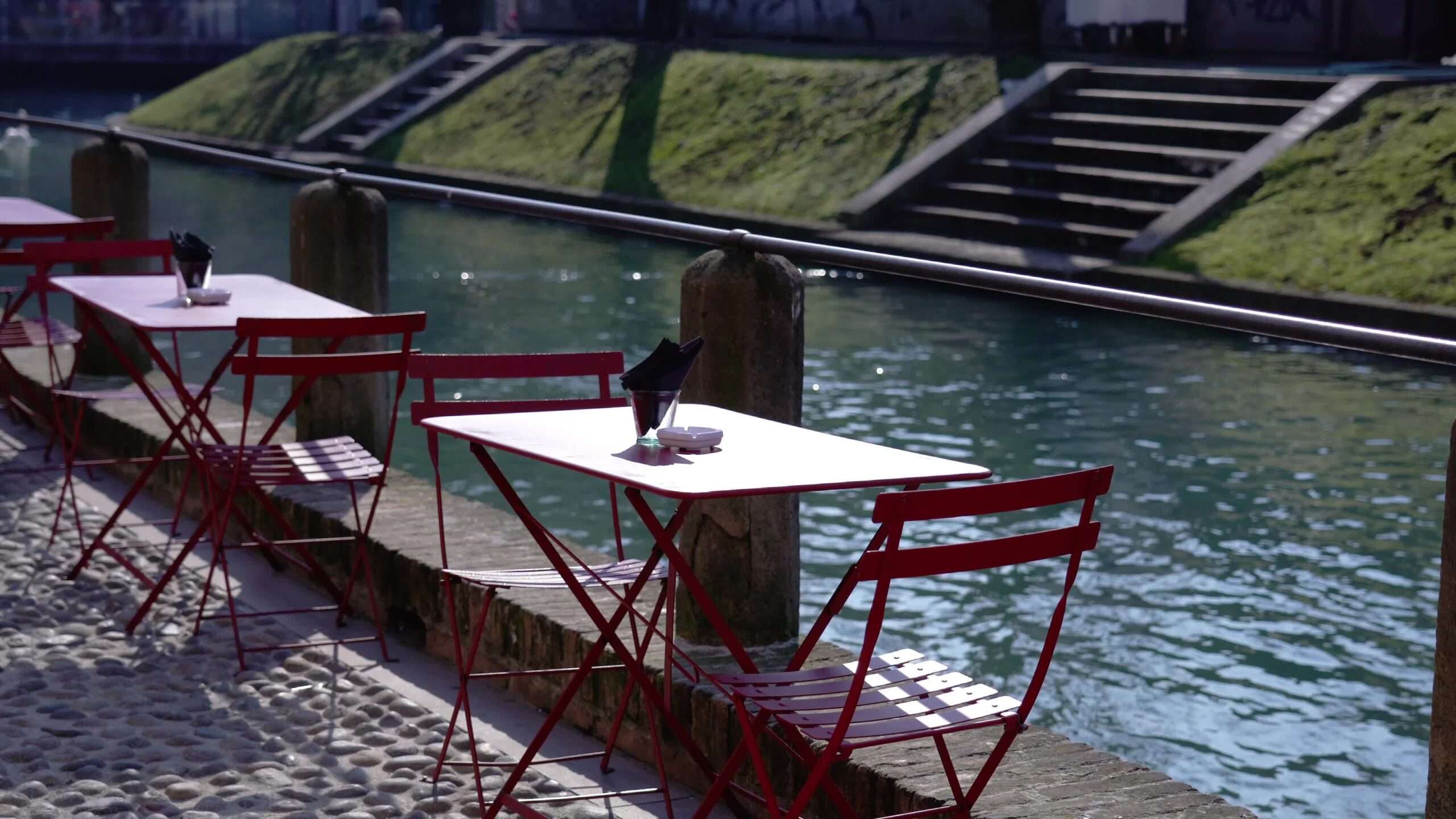 Tavole e sedie del ristorante davanti il fiume della città