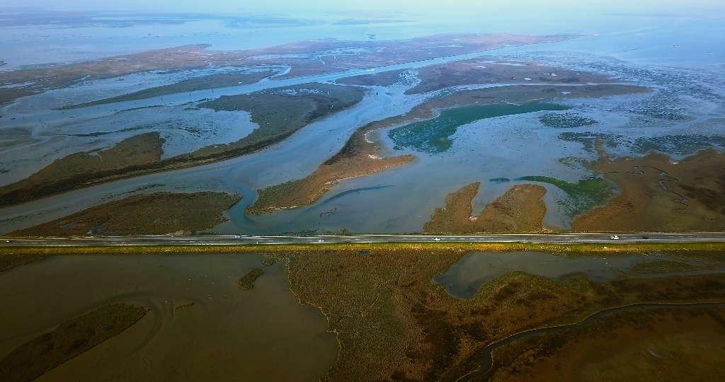 Asphalt highway with fast car traffic among Venetian lagoon