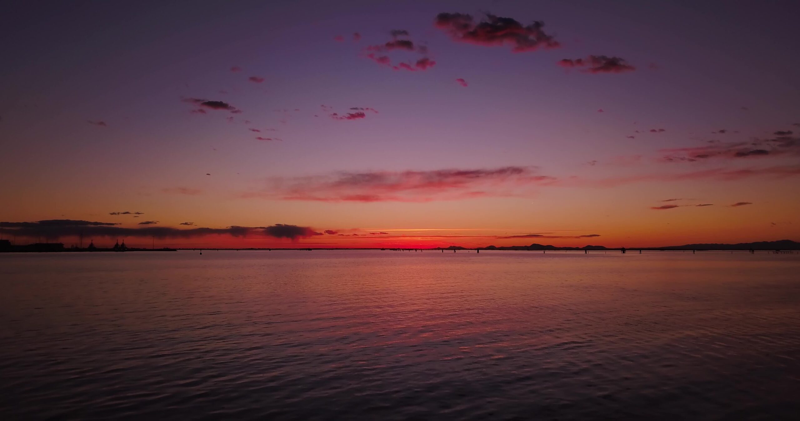 Boundless sea with ripple against shellfish farm at sunset