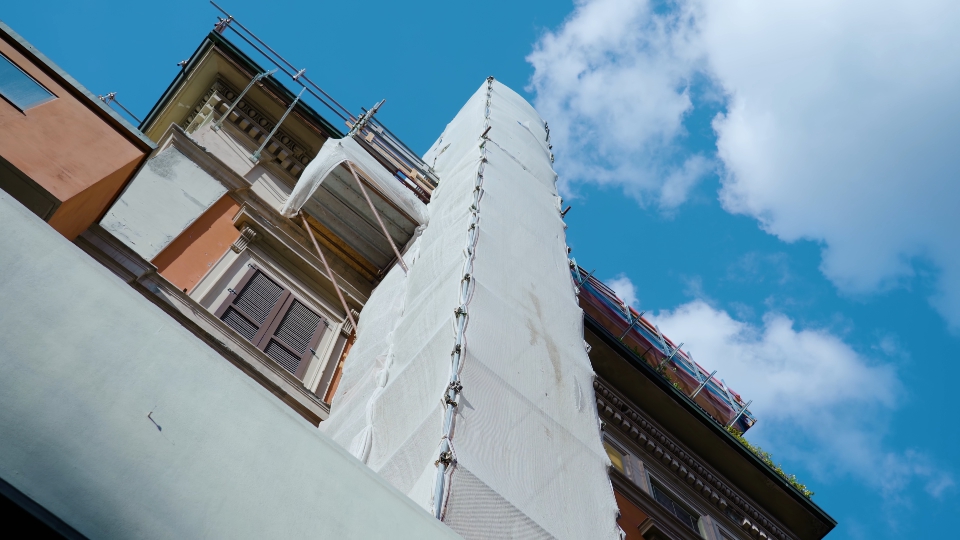 Costruire con tessuto bianco su alto ponteggio metallico