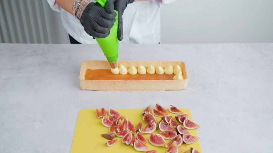 La persona decora il biscotto con la crema usando il sac a poche