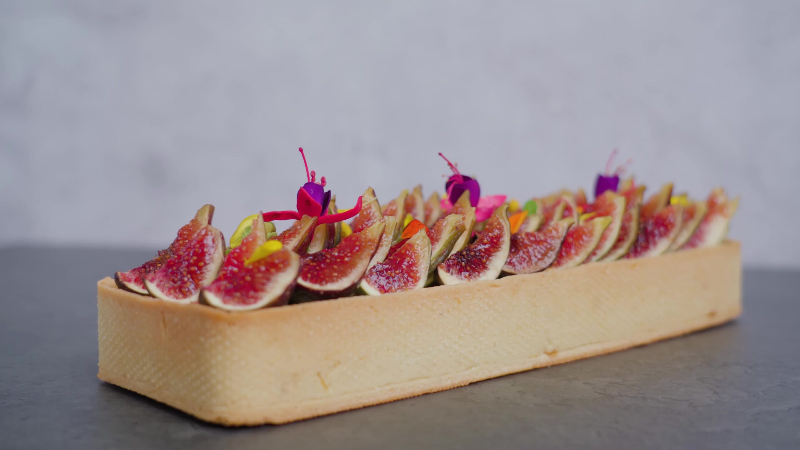 Squared biscuit decorated with juicy fig slices and flowers