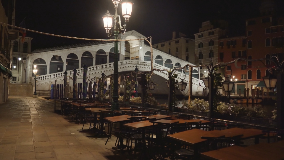 Tavoli da caffè davanti il famoso ponte di Rialto di notte