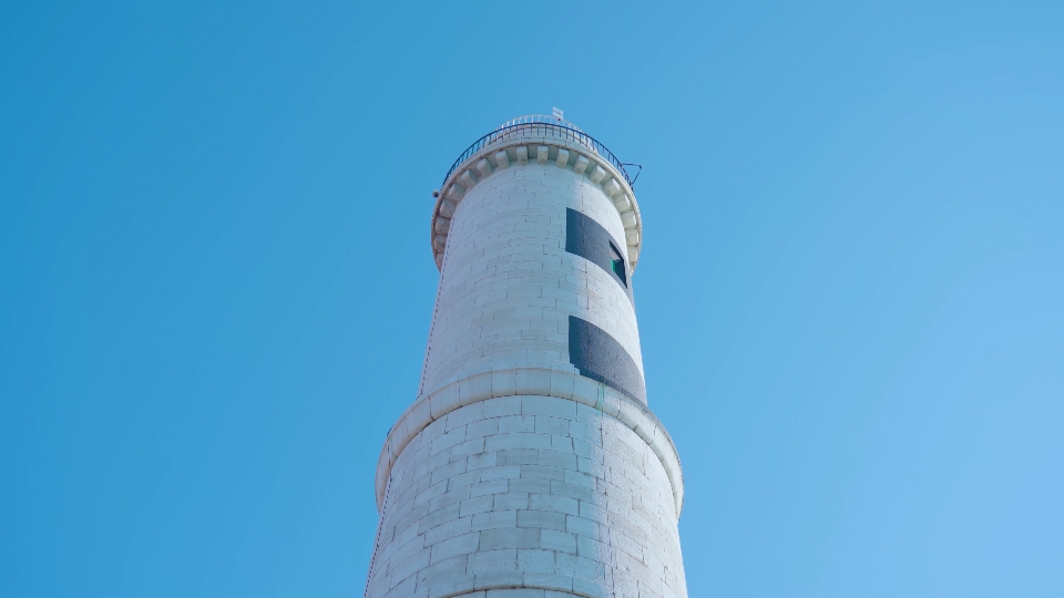 High stone lighthouse tower in Murano against blue sky