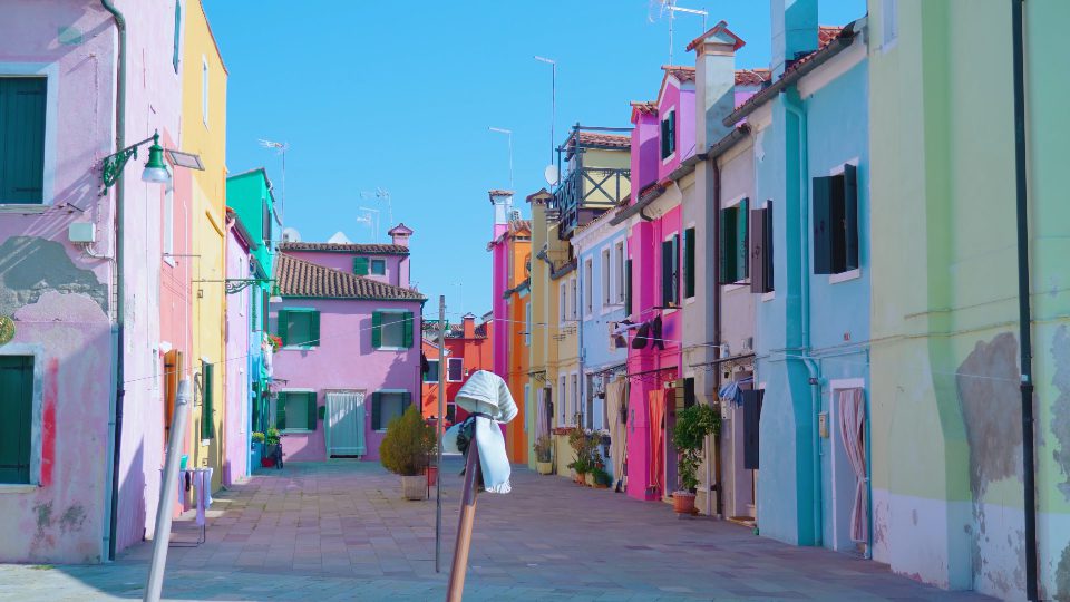 Houses stand on Burano street with clothes on clothesline