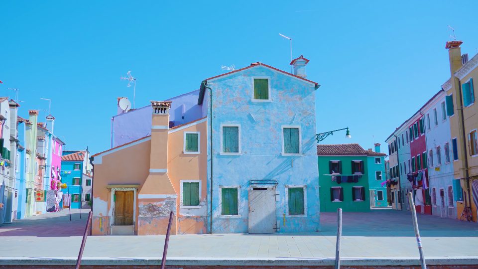 Quiet empty street with colorful houses in morning in Burano
