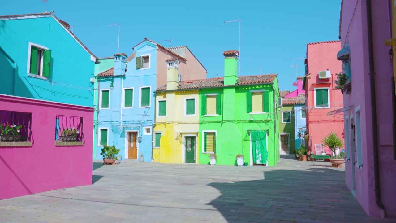 Rows of multi-colored houses standing under bright sunlight