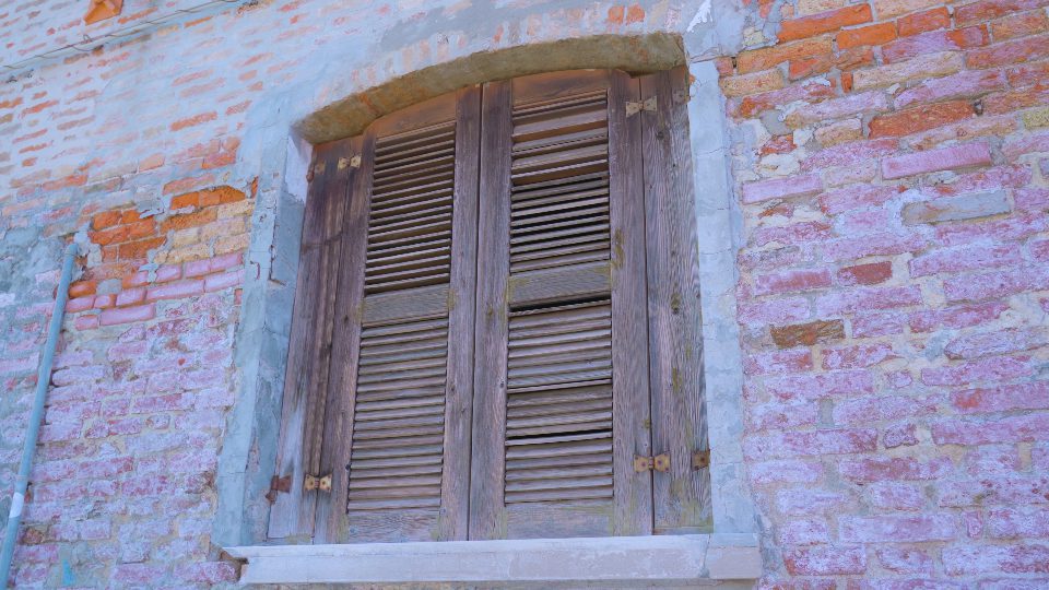 Window closed with shutters on abandoned building in Burano