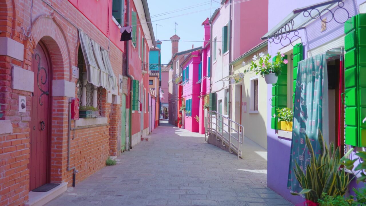 Street between old bright colored houses with flowers
