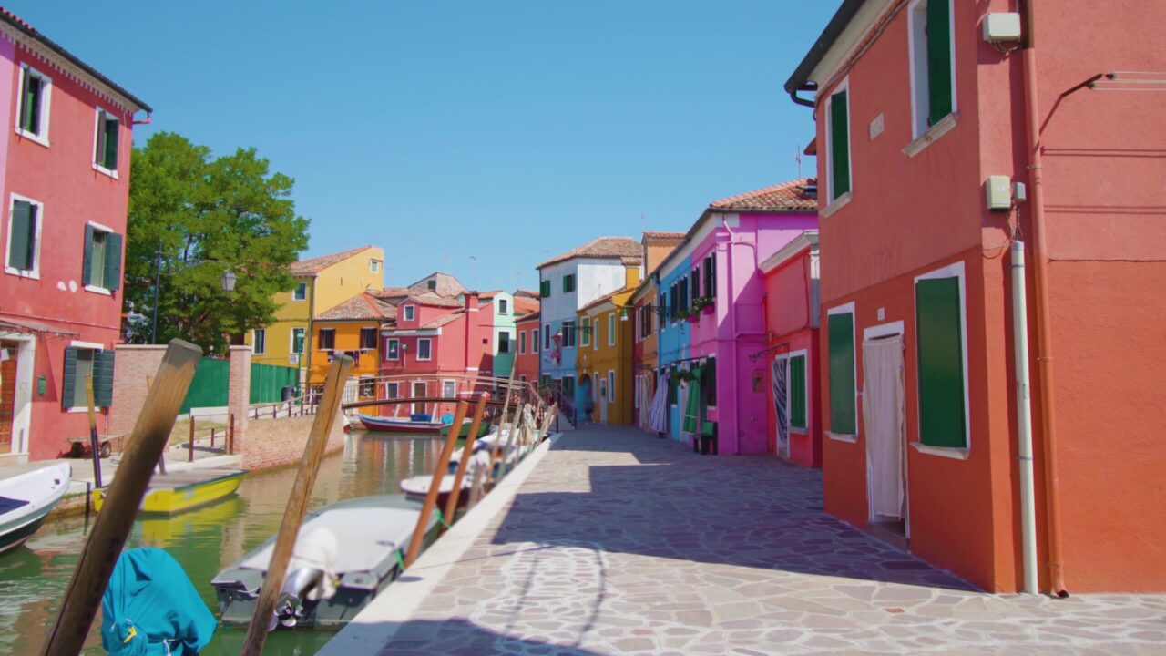 Rows of colored houses along Burano water channel in morning