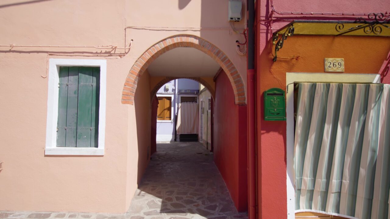 Short arch walkway between old houses with cobbled road