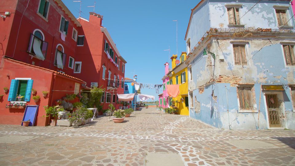 Strada con stendibiancheria al vento tra case colorate