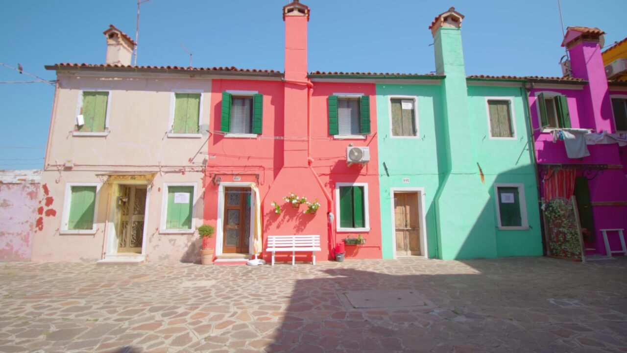 Street with multi-colored houses and flowerpots with plants