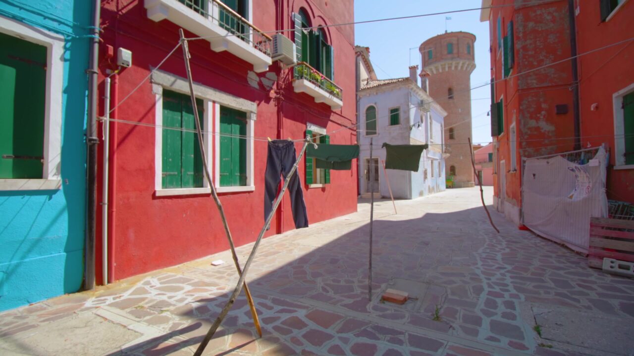 Clothes drying on clothesline between colorful houses walls