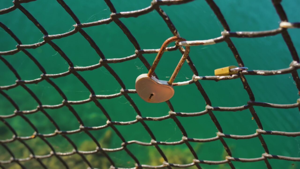 Serratura a forma di cuore appesa alla griglia di ferro