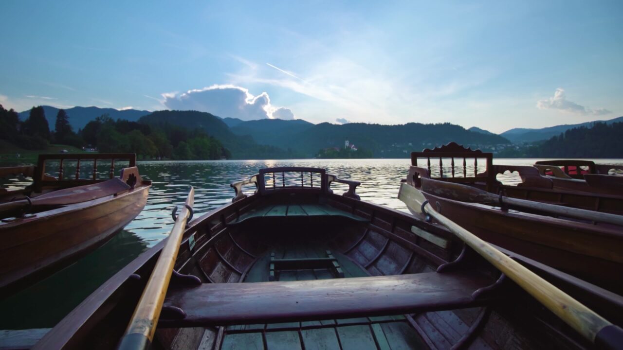 Molo con barche di legno ormeggiate vicino al lago di Bled al crepuscolo
