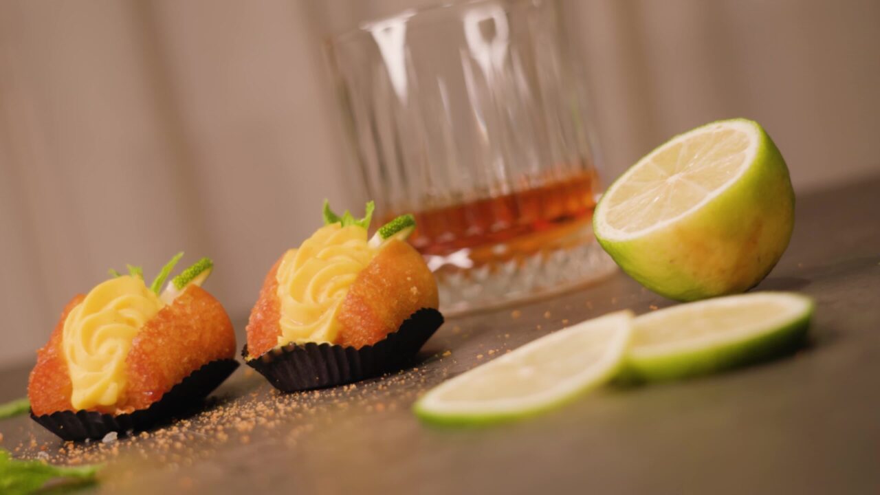 Le torte decorate giacciono su un tavolo di marmo vicino a lime e cocktail