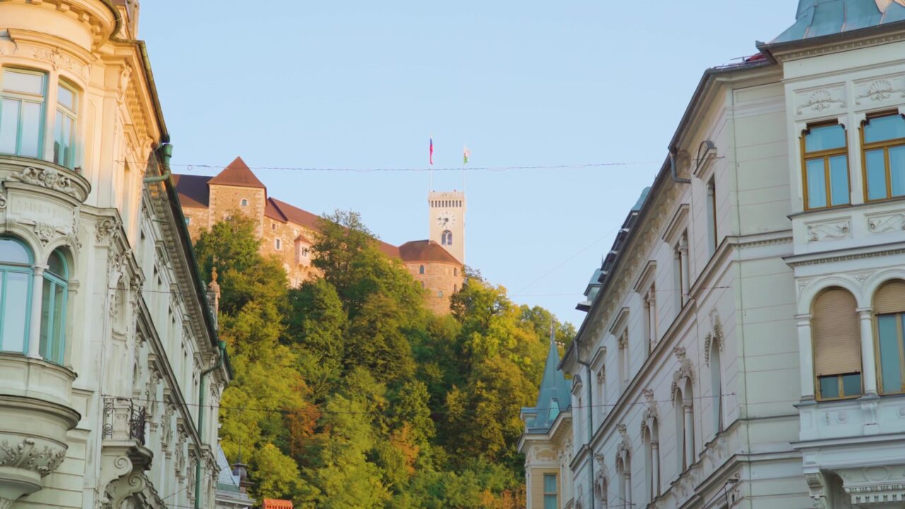 Old castle on hill top behind buildings on Ljubljana street