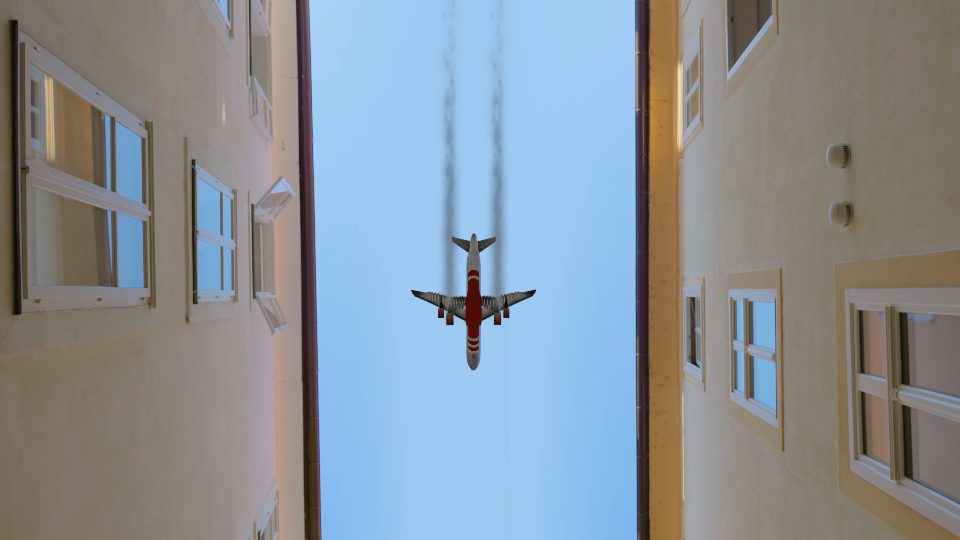 Aereo  vola tra gli edifici nel cielo blu in città