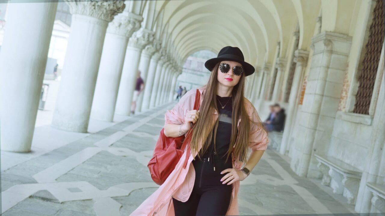 La donna sicura cammina sulla galleria del palazzo con le grandi colonne