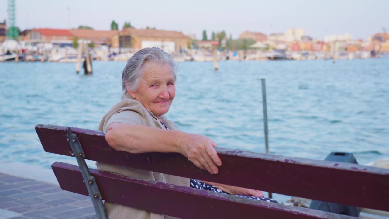 Elderly woman enjoys seascape by lagoon in Chioggia