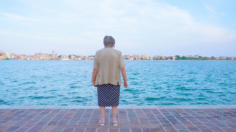 Donna anziana guarda laguna di Venezia