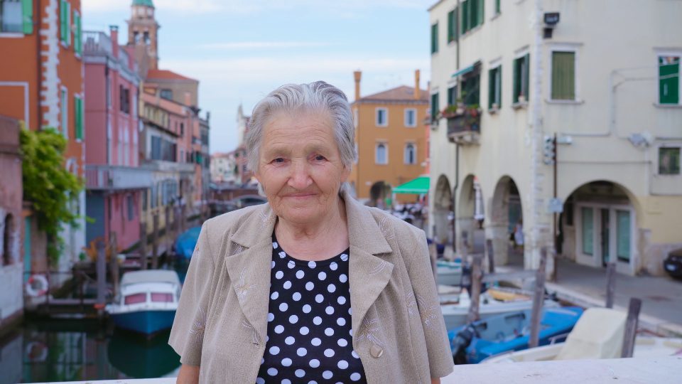 Elderly Woman Pausing on the Bridge among Venetian Houses – 4K