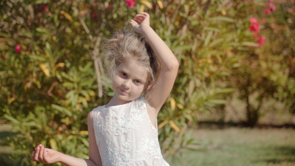 La bambina sorridente scuote la testa per lasciare sciolti i lunghi capelli biondi