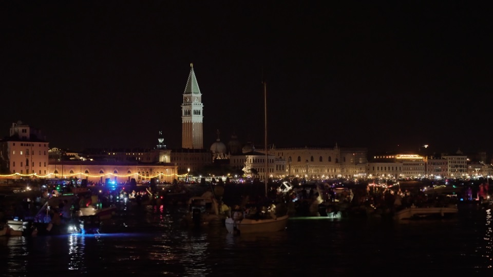 La gente naviga sulle tradizionali barche veneziane illuminate di notte