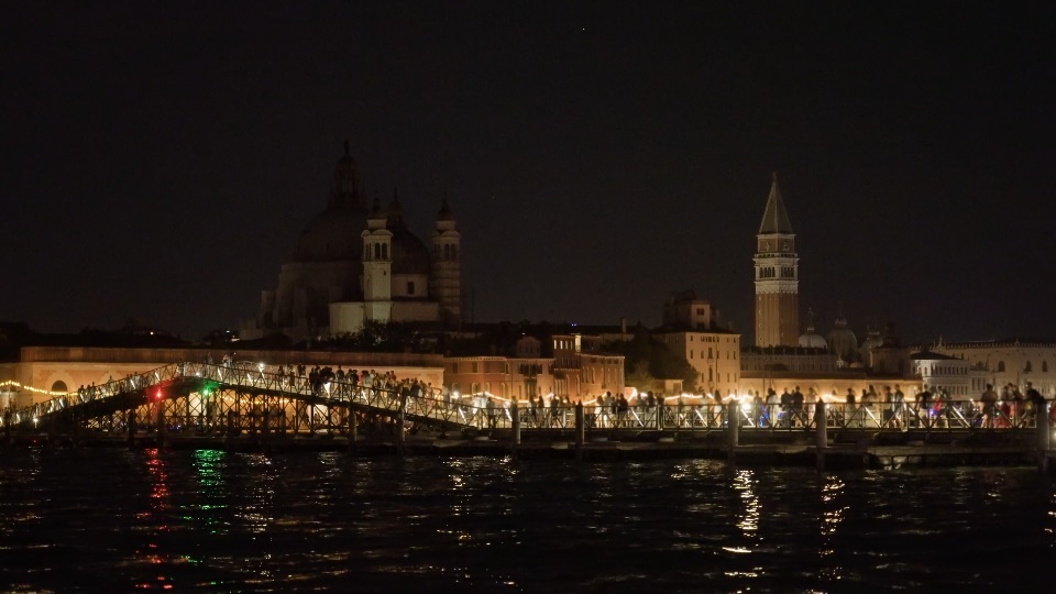 People walk on long pontoon bridge on Feast of Redeemer