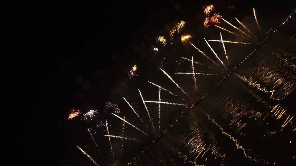 Fuochi d’artificio luminosi lanciati in aria che esplodono contro il cielo notturno