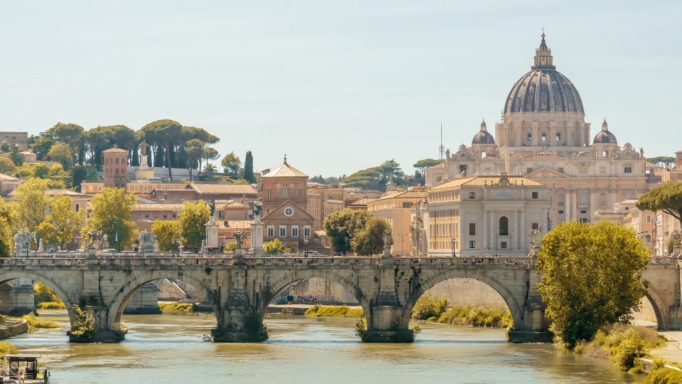 Saint Angelo bridge surrounded by lush green trees in Rome