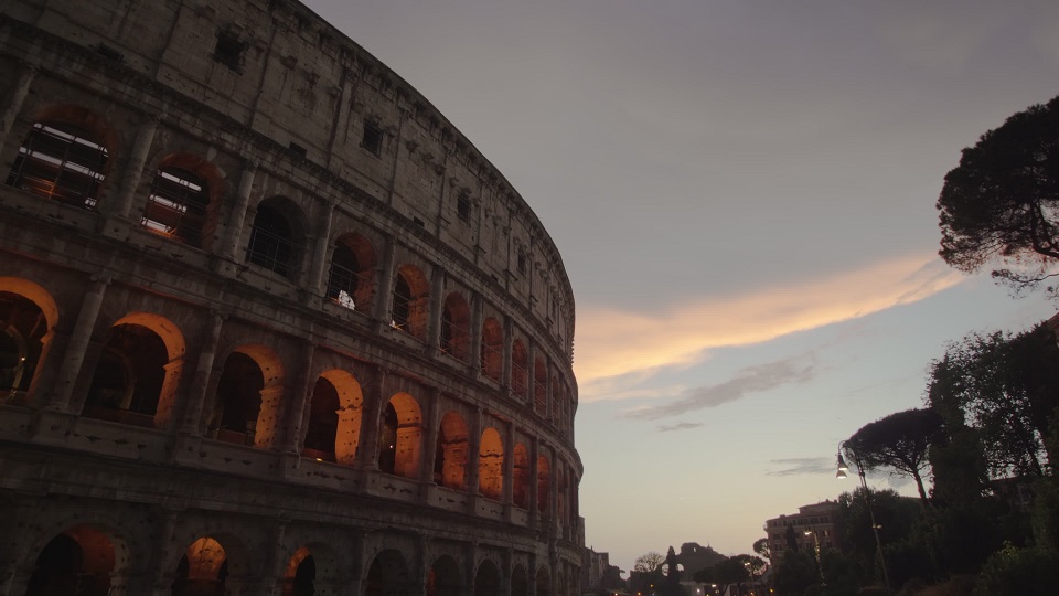 Colosseo illuminato di luce interiore al tramonto a Roma