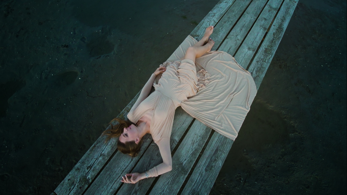 Model lying on the wooden pier