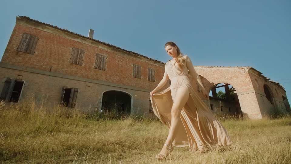 Elegant model walks in front of old building