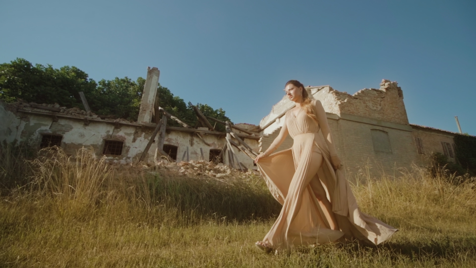 Bellissima donna elegante cammina davanti edificio rovinato