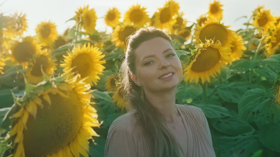 Woman appears among yellow sunflowers