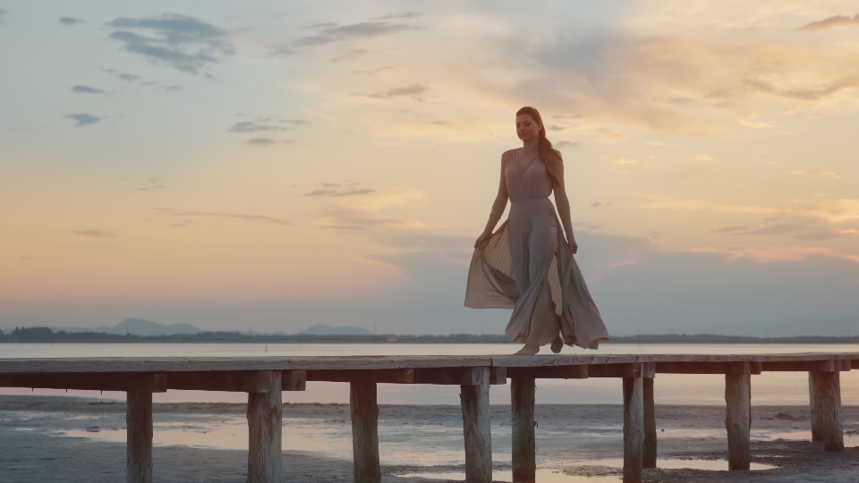 Elegant woman parades on the walkway of the lagoon