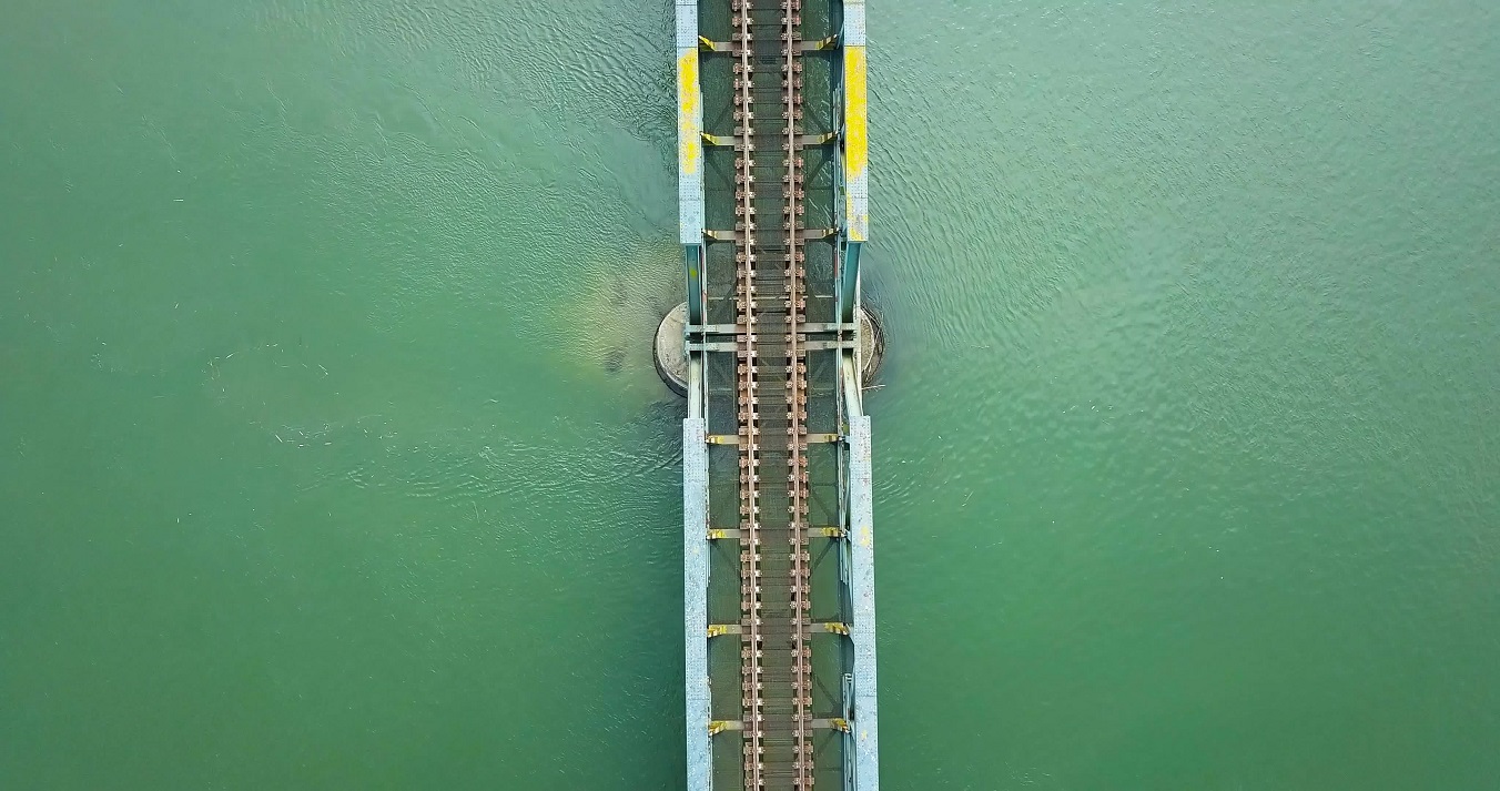 Steel bridge with train tracks over a river